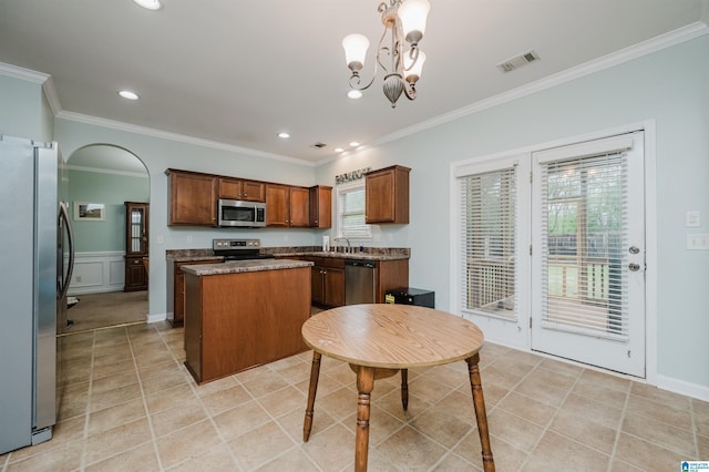 kitchen with visible vents, light tile patterned floors, a sink, stainless steel appliances, and a kitchen island