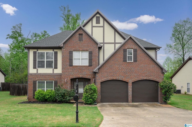 tudor-style house featuring a garage, driveway, a front lawn, and brick siding