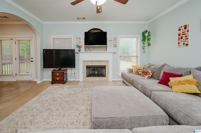 tiled living area with visible vents, baseboards, a ceiling fan, and crown molding