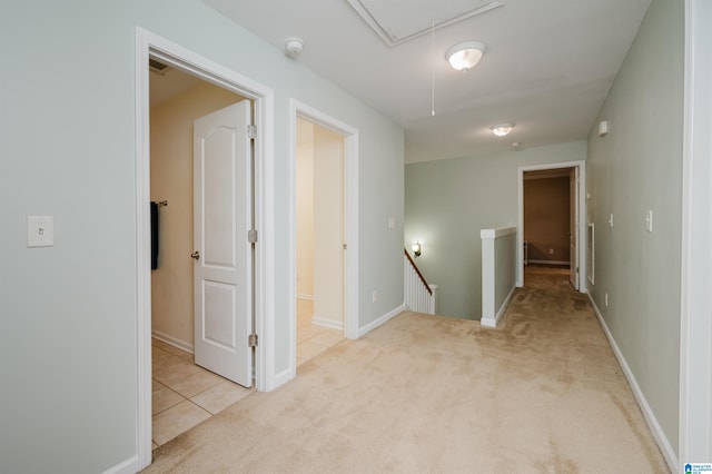 hall with carpet floors, baseboards, an upstairs landing, and attic access