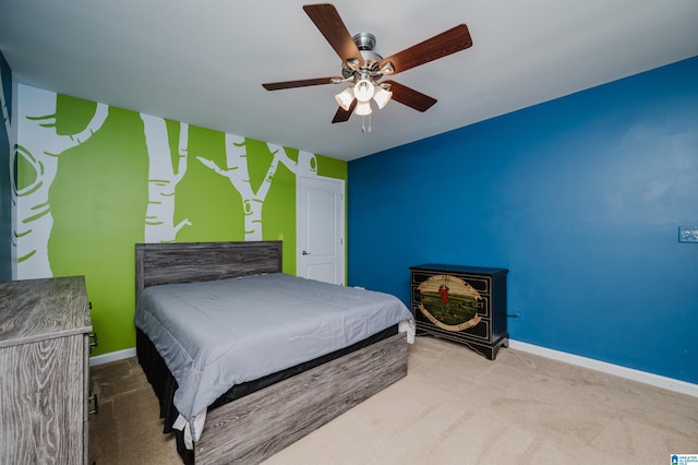 bedroom featuring an accent wall, baseboards, a ceiling fan, and carpet floors
