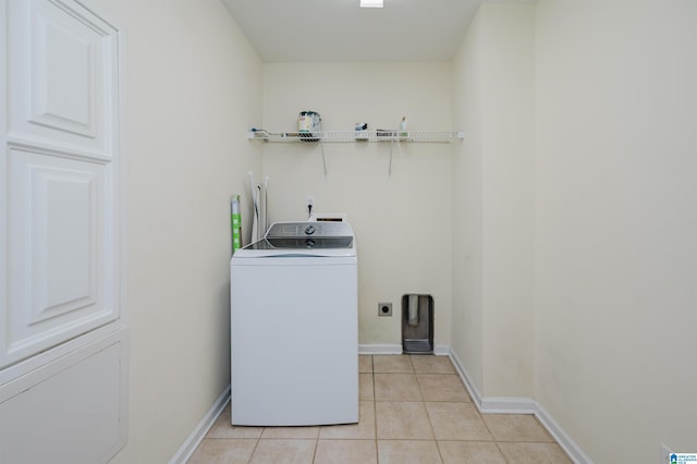 laundry room with washer / dryer, laundry area, baseboards, and light tile patterned flooring