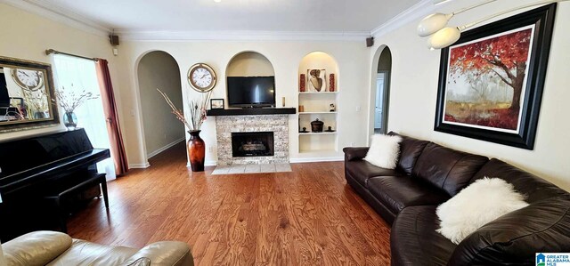 living room with crown molding, wood finished floors, and built in shelves