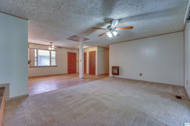 unfurnished living room featuring heating unit, visible vents, carpet, and a ceiling fan