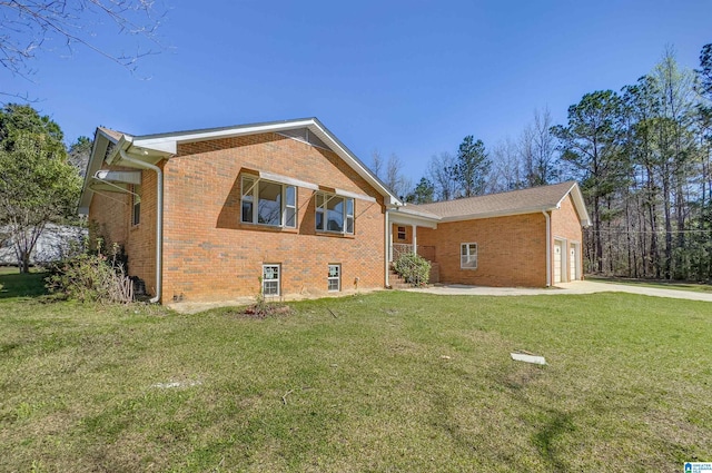 exterior space with a garage, driveway, brick siding, and a lawn