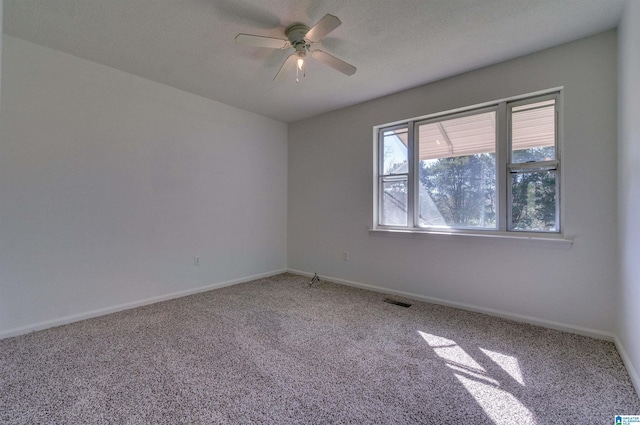 spare room featuring visible vents, baseboards, ceiling fan, and carpet flooring