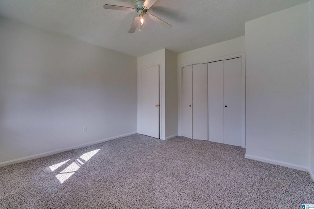 unfurnished bedroom with baseboards, a closet, carpet floors, and ceiling fan