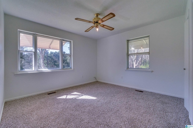spare room featuring a ceiling fan, visible vents, carpet floors, and baseboards