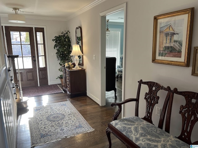 foyer entrance with dark wood finished floors, baseboards, and ornamental molding