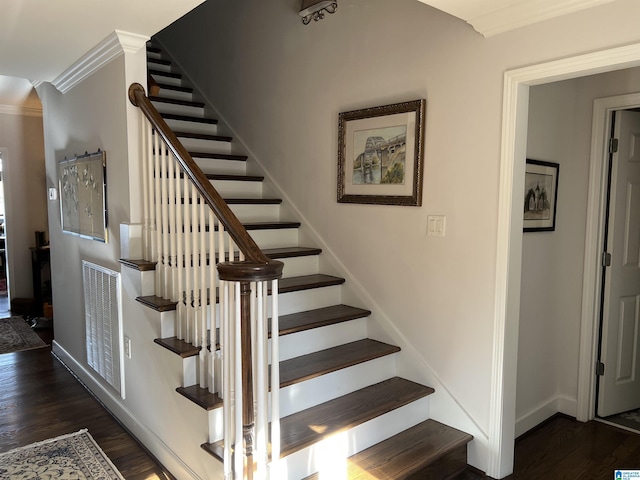 stairway featuring visible vents, crown molding, baseboards, and wood finished floors