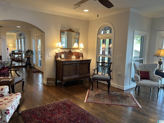 sitting room with wood finished floors, visible vents, arched walkways, and ceiling fan