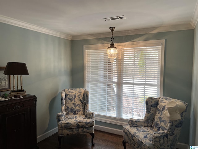sitting room featuring visible vents, wood finished floors, baseboards, and ornamental molding