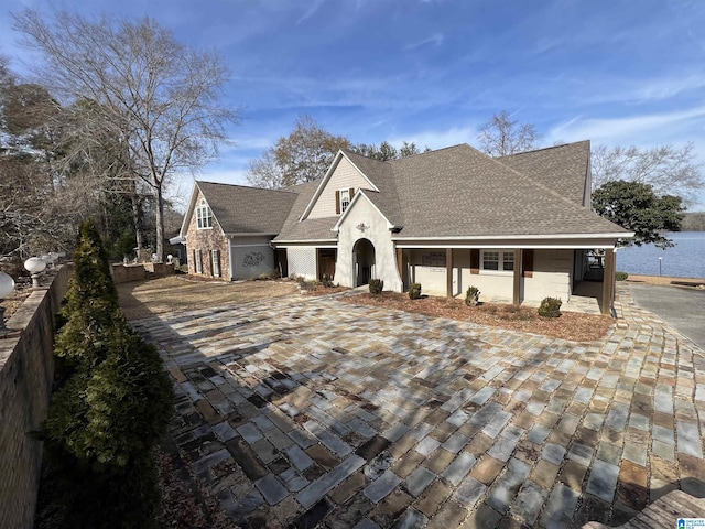 view of front of property with fence, roof with shingles, and stucco siding