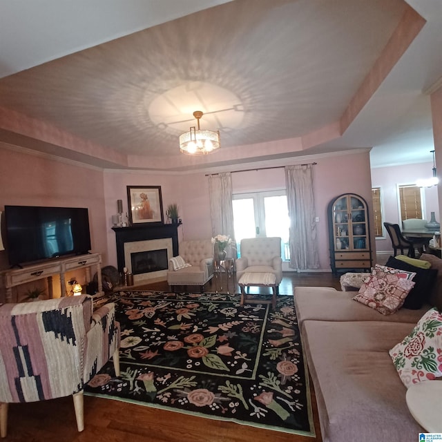 7459 15th Street Rd, Bessemer, AL 35023 - living room featuring a fireplace, a raised ceiling, a notable chandelier, and wood finished floors