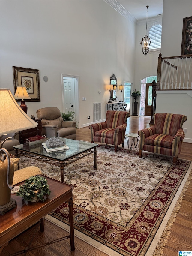 1533 Highland Lakes Trl, Birmingham, AL 35242 - living room with a towering ceiling, crown molding, wood finished floors, a chandelier, and arched walkways