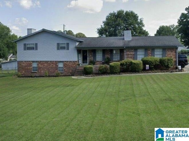 1804 Ragsdale Rd, Cullman, AL 35055 - split level home featuring a front yard, brick siding, and a chimney