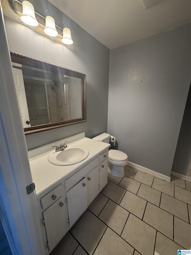1804 Ragsdale Rd, Cullman, AL 35055 - bathroom featuring vanity, baseboards, a stall shower, tile patterned flooring, and toilet