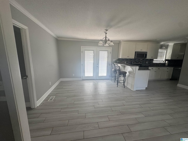 1804 Ragsdale Rd, Cullman, AL 35055 - kitchen with plenty of natural light, a breakfast bar, stainless steel range oven, decorative backsplash, and a notable chandelier
