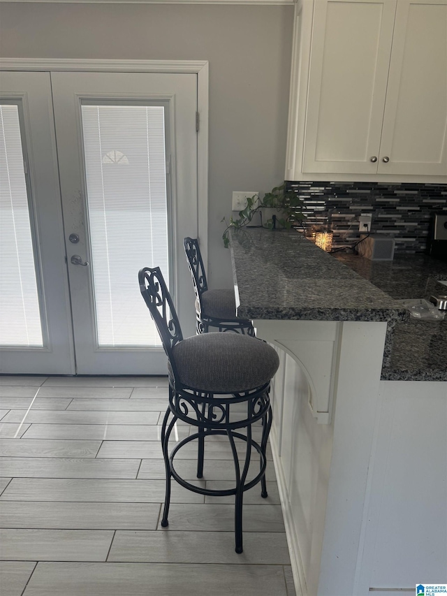 1804 Ragsdale Rd, Cullman, AL 35055 - kitchen featuring light wood finished floors, decorative backsplash, french doors, and white cabinetry