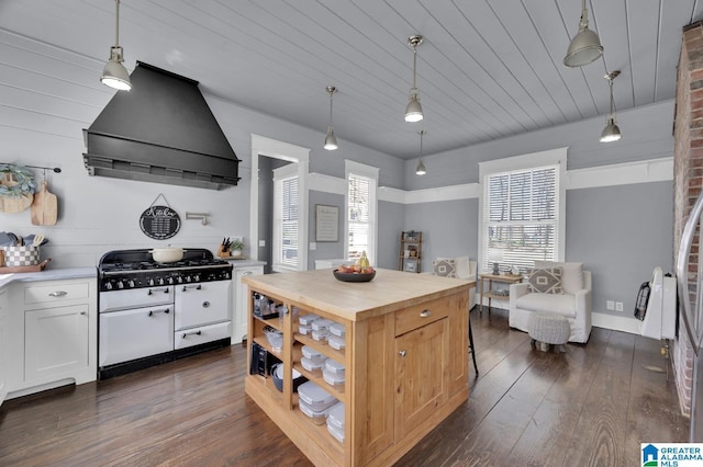 kitchen with custom exhaust hood, cooktop, dark wood-type flooring, white cabinetry, and butcher block counters