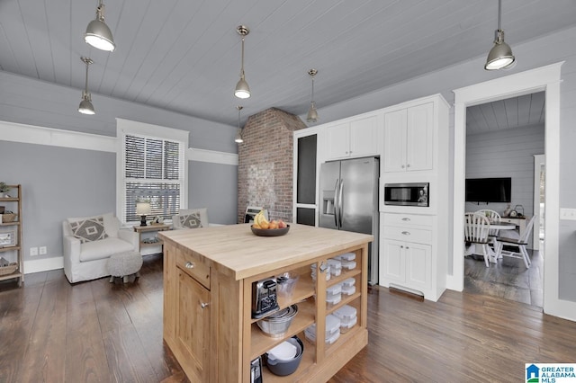 kitchen featuring pendant lighting, butcher block countertops, dark wood-style flooring, and stainless steel appliances