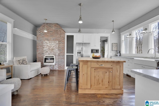 kitchen featuring butcher block countertops, heating unit, open floor plan, appliances with stainless steel finishes, and dark wood-style flooring