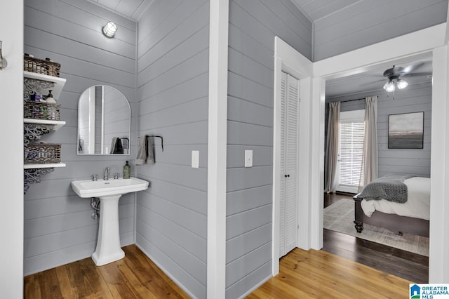 bathroom featuring wood-type flooring and wood walls