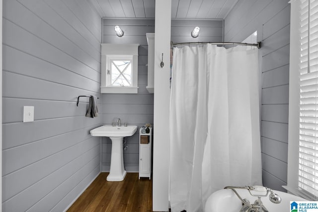 full bathroom featuring curtained shower, wood finished floors, and a sink