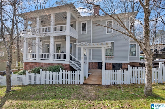 greek revival inspired property with a balcony, a ceiling fan, a pergola, a chimney, and a fenced front yard