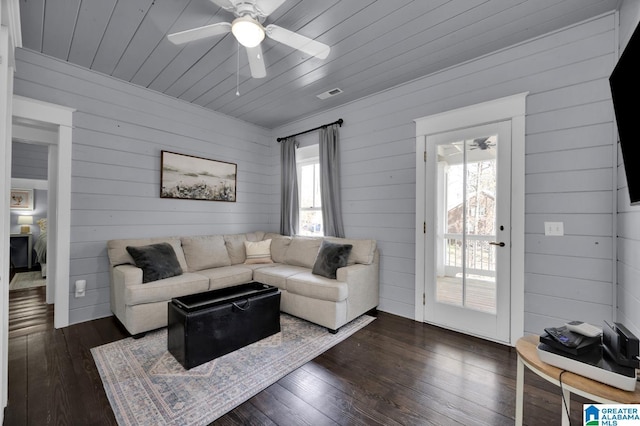 living room with dark wood-style floors, visible vents, wood ceiling, and a ceiling fan
