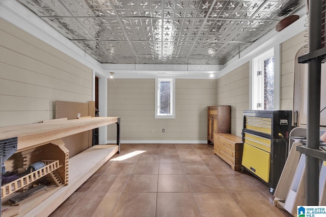 interior space featuring tile patterned flooring, plenty of natural light, and wood walls