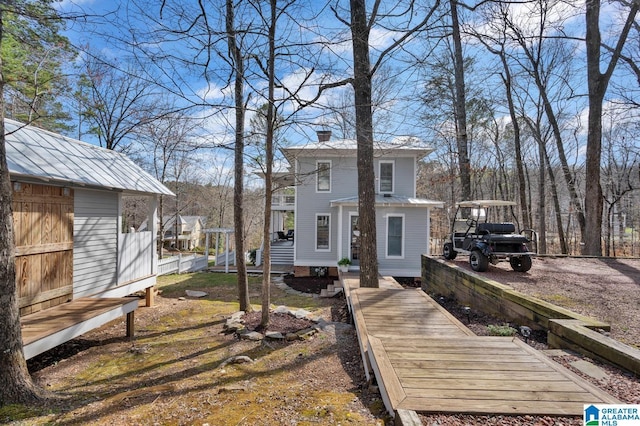 rear view of property with an outbuilding and a chimney
