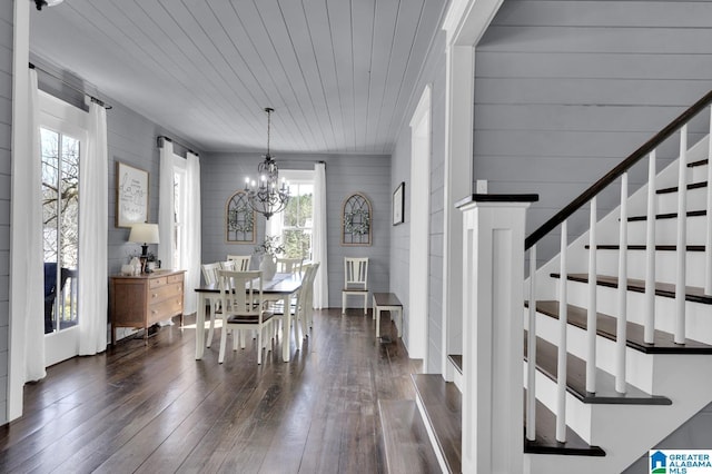 dining space with a chandelier, wooden ceiling, dark wood-style floors, and stairs