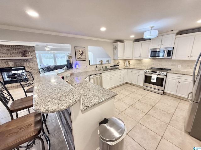 360 Frankies Rd, Vincent, AL 35178 - kitchen featuring a breakfast bar area, tasteful backsplash, appliances with stainless steel finishes, and a peninsula