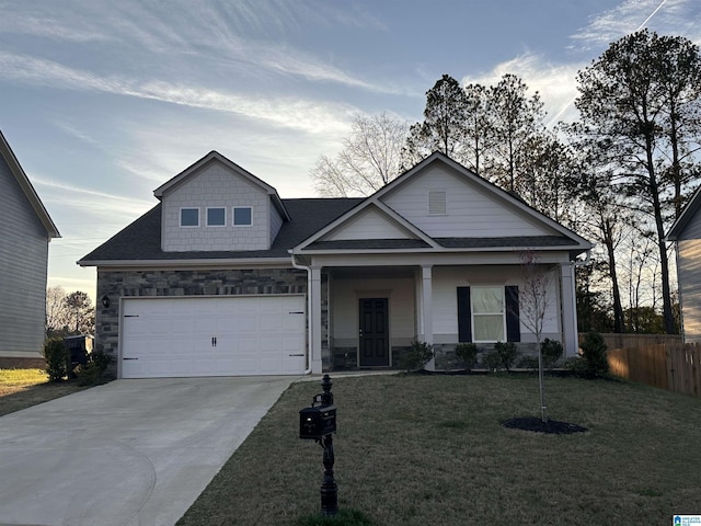 view of front of property with stone siding, a front yard, concrete driveway, and fence
