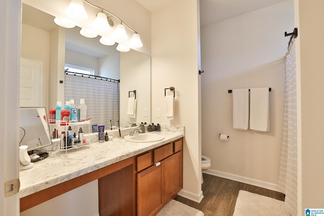 full bathroom with a shower with curtain, vanity, toilet, baseboards, and wood finished floors