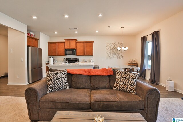 living room with wood finished floors, visible vents, a notable chandelier, and recessed lighting