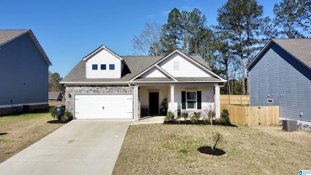 view of front of property with fence, roof with shingles, concrete driveway, and a front yard