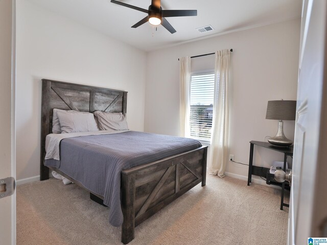 bedroom featuring baseboards, visible vents, a ceiling fan, and light colored carpet
