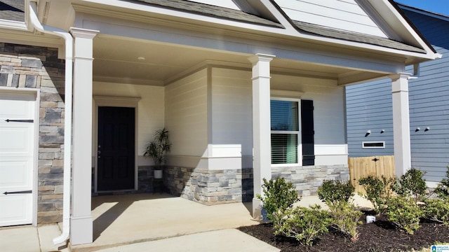 entrance to property featuring stone siding and covered porch