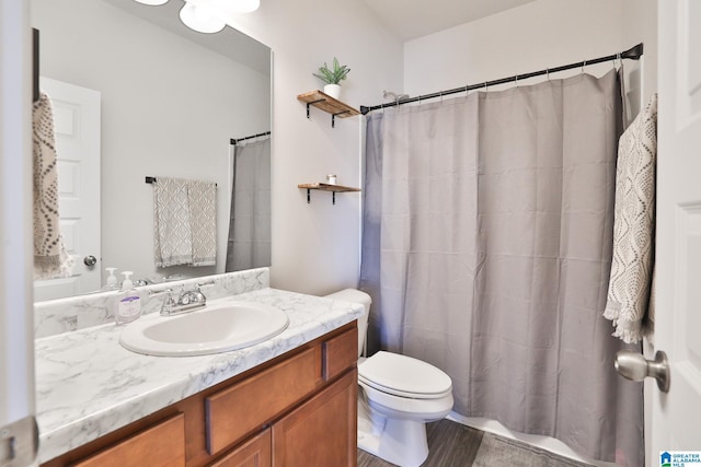 full bath with a shower with curtain, toilet, and vanity