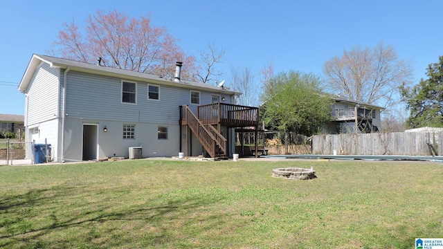 rear view of house featuring a fire pit, a deck, stairway, and fence
