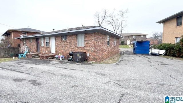 7709 7th Ave S, Birmingham, AL 35206 - back of property featuring central AC unit, driveway, fence, and brick siding