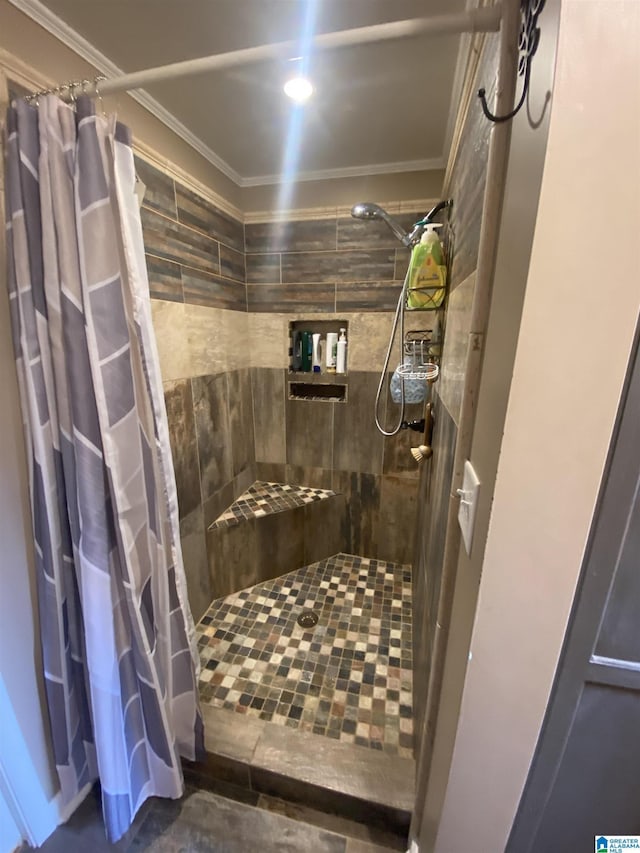 bathroom with tiled shower and crown molding