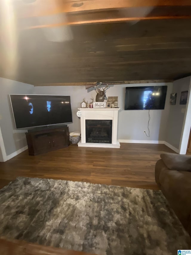 unfurnished living room featuring baseboards, wood finished floors, and a glass covered fireplace
