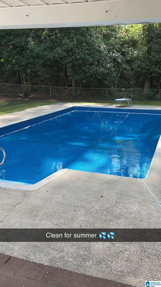 view of pool featuring a diving board, fence, and a fenced in pool