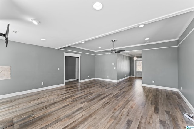 empty room featuring a ceiling fan, crown molding, baseboards, and wood finished floors