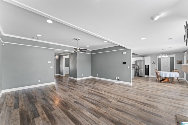 unfurnished living room featuring recessed lighting, ceiling fan with notable chandelier, baseboards, visible vents, and wood finished floors