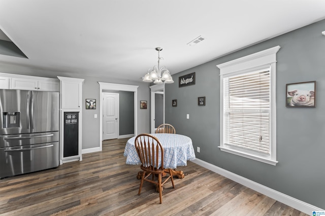 dining room with baseboards, a notable chandelier, visible vents, and dark wood-type flooring