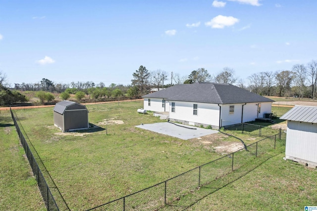 view of yard with fence, an outbuilding, a patio area, and a storage shed